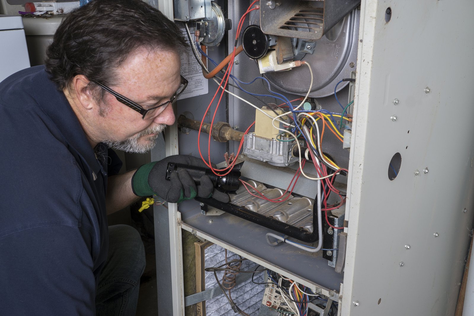 Experienced technician repairing a furnace in Maysville, IA